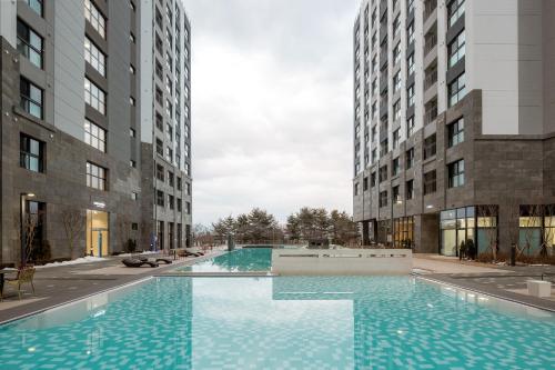 una gran piscina entre dos edificios altos en Chestertons Sokcho en Sokcho