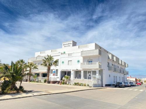 a large white building with palm trees in front of it at Hotel Blanca Brisa Cabo de Gata in El Cabo de Gata