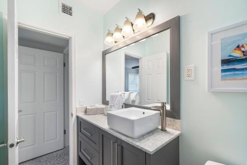 uma casa de banho com um lavatório e um espelho grande em Florida Seaside Get Away- 50 Steps to Beach em Boynton Beach