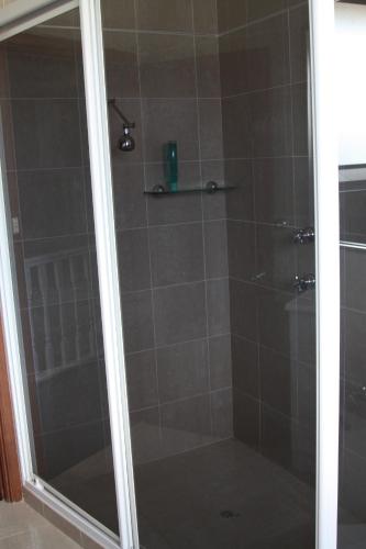 a shower with a glass door in a bathroom at Bennett's Bliss - Ocean View, 5 Bedrooms, 14 Guest in Forster