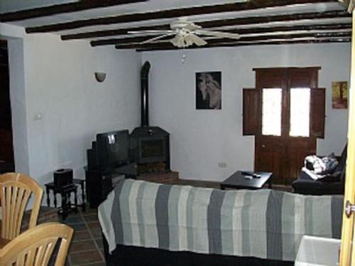 1 dormitorio con 1 cama, mesa y sillas en Casa dos ponies, en Ríogordo