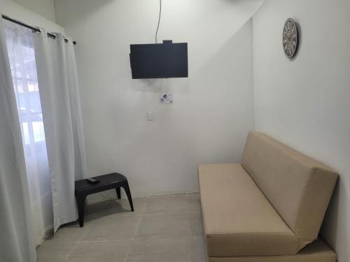 uma sala de estar com um sofá e uma televisão na parede em Apartamento Turistico Luna del Mar em San Andrés