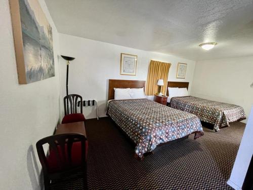 a hotel room with two beds and a table and chairs at Desert Inn in Mojave