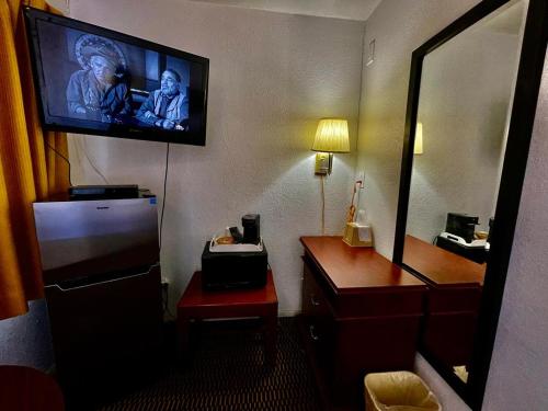 ein Hotelzimmer mit einem TV an der Wand in der Unterkunft Desert Inn in Mojave