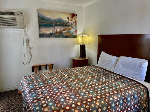 a hotel room with a bed and a painting on the wall at Desert Inn in Mojave