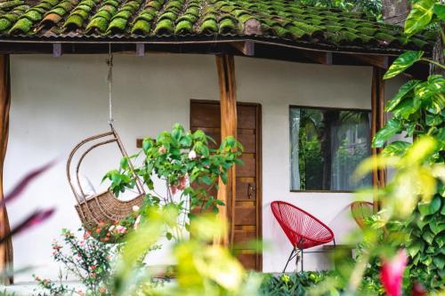 a red chair in front of a house at SoulShine in Playa Avellana