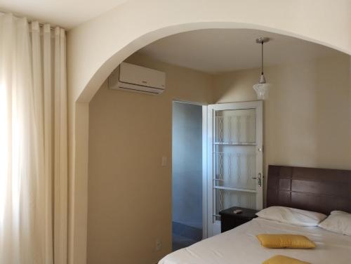 a bedroom with a bed and an arched doorway at VIA SPE - Pousada in Belo Horizonte