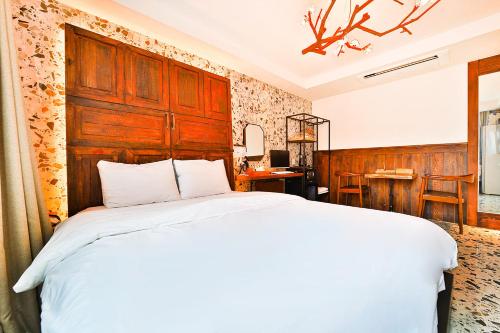 a bedroom with a large bed with a wooden headboard at Hotel February Tongyeong Jukrim in Tongyeong