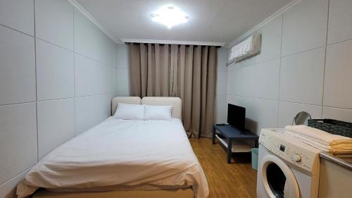 een kleine kamer met een bed en een televisie bij Stay 230 in Danyang