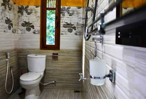 a bathroom with a toilet and a sink at Jayathissa Villa 