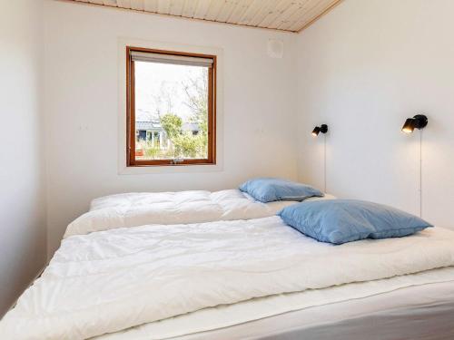 Duas camas num quarto branco com uma janela em Holiday home Vordingborg X em Vordingborg