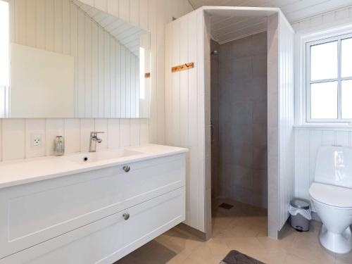 La salle de bains est pourvue d'un lavabo et de toilettes. dans l'établissement Holiday home Martofte XI, à Martofte
