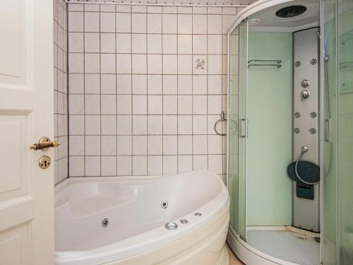 羅蒙柯克比的住宿－Holiday home Rømø XVII，带浴缸和玻璃淋浴间的浴室。