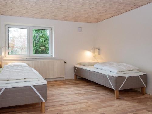 sypialnia z 2 łóżkami i oknem w obiekcie Holiday home Rømø XVII w mieście Rømø Kirkeby