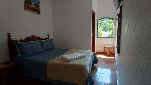a bedroom with a bed and a window at Pousada Santo Expedito in Tiradentes