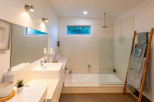 a bathroom with a tub and a sink and a shower at Pandora Beach House in Venus Bay