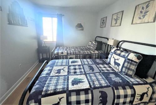 1 dormitorio con 2 camas con edredón en Our Place in the Smokies, en Gatlinburg