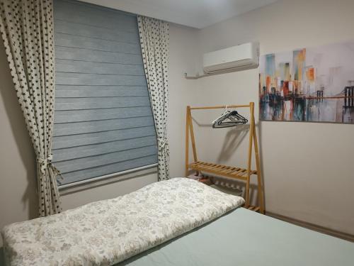 1 dormitorio con 1 cama y ventana con ventilador en Happy Accomation Houses 192mt toHarbour en Marmaris
