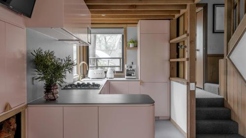 a kitchen with white cabinets and a stairway at Blairs in Dinner Plain