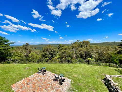 a patio with chairs and tables in a grassy field at Linden Lodge in Linden