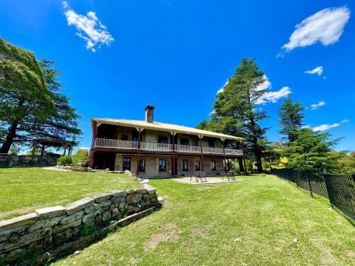 an old house with a stone wall in front of it at Linden Lodge in Linden