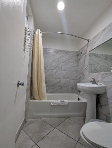 a bathroom with a sink and a tub and a toilet at BEST MOTEL on Historic Route 66, Barstow in Barstow