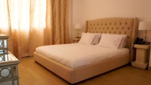 a bedroom with a large white bed with a large window at Hotel Delphin-Nouadhibou in Nouadhibou