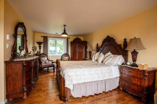 a bedroom with a bed with wooden furniture and a mirror at Bed and Breakfast Panorama in Saint-Laurent-de-l'ile d'Orleans