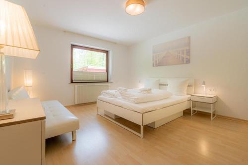a white bedroom with a bed and a window at Wohnung-C-305 in Böhl