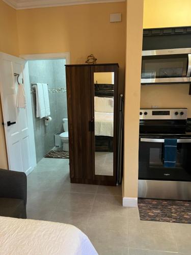 a room with a kitchen with a stove and a bathroom at Negril Studio One in Negril