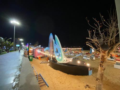 a sandy beach at night with a building on it at Hotel Hoàng Hưng Quy Nhơn in Quy Nhon
