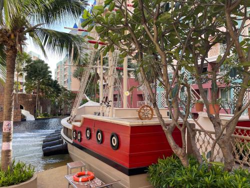 un bateau est amarré dans un canal planté de palmiers. dans l'établissement Grande Caribbean Condo Resort, à Pattaya (sud)
