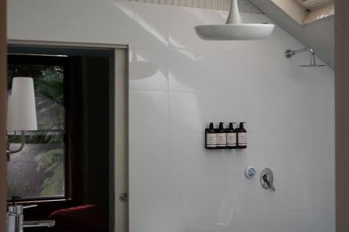 a bathroom with bottles of wine on the wall at Lyra Kangaroo Valley in Kangaroo Valley