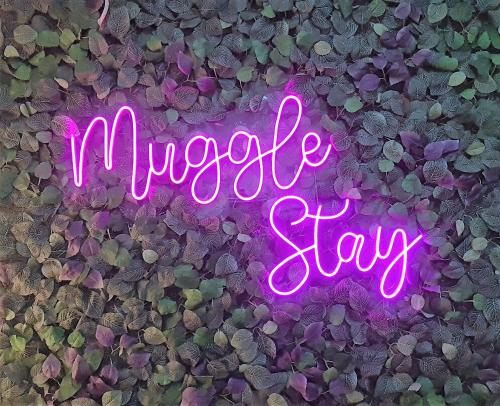a neon sign that says wookie stay on a wall at Muggle Stay Guest House - Bonifacio Global City Taguig in Manila