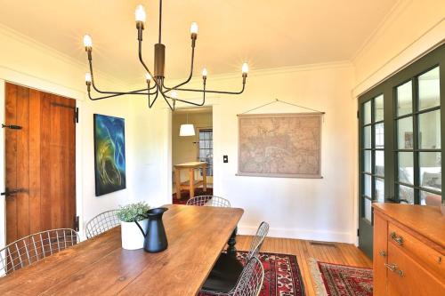 a dining room with a wooden table and a chandelier at Family Summer House in the Eastern Townships in Ayer's Cliff