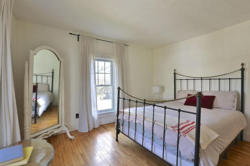 a bedroom with a bed and a large mirror at Family Summer House in the Eastern Townships in Ayer's Cliff