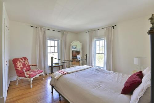 1 dormitorio con 1 cama grande y 1 silla en Family Summer House in the Eastern Townships, en Ayers Cliff