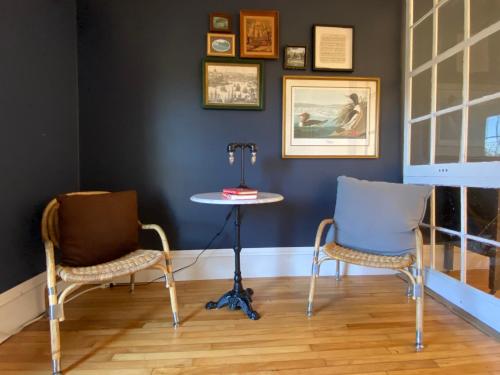 two chairs and a table in a room with a wall at Family Summer House in the Eastern Townships in Ayer's Cliff