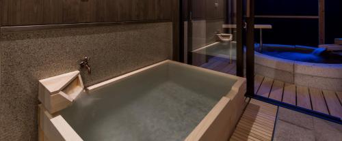 a large bath tub in a bathroom with a jacuzzi at Inishie no Yado Keiun in Izumo