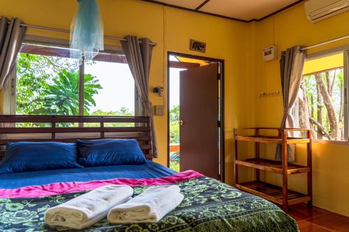 1 dormitorio con 1 cama con toallas en Wild Hippie Chang 