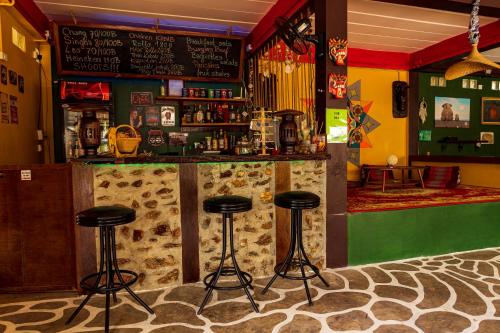 a bar with three stools in a room at Wild Hippie Chang in Ban Nong Si Chaeng