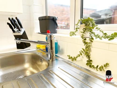 ウィガンにあるKozyGuru / Wigan / 2BR 4Beds / Newly Refurbished Stylish Holiday House / Close to Big Retail Park / UWNE034の窓際の台所用シンク