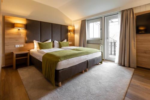 a bedroom with a large bed and a large window at Hotel Fröhlich-Höche in Uslar