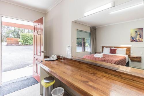 a bedroom with a bed and a large mirror at Black Forest Motel in Macedon