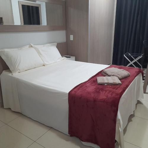 1 cama blanca grande con 2 toallas en Flat - VISTA PARA PISCINA en Brasilia