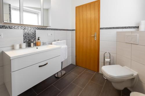 een badkamer met een witte wastafel en een toilet bij Hotel Fröhlich-Höche in Uslar
