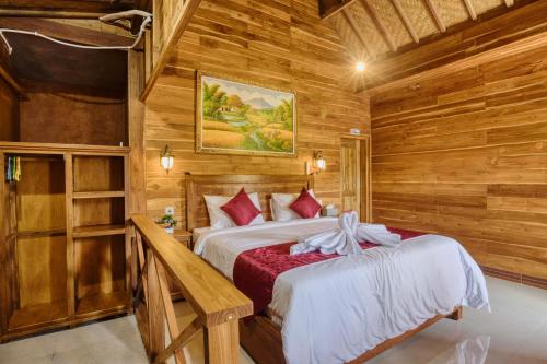 een slaapkamer met een bed in een houten hut bij Linas Villas in Nusa Penida