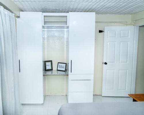 um quarto branco com uma porta e um sofá em Francis Nook Belle Garden Room em San Juan
