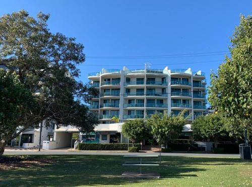 a large apartment building with a park in front of it at Alby’s - Cotton Tree in Maroochydore