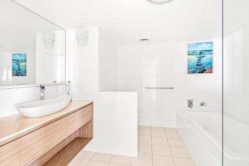 a white bathroom with a sink and a tub at Crown Towers Resort - Private 3 Bedroom Apartment in Gold Coast